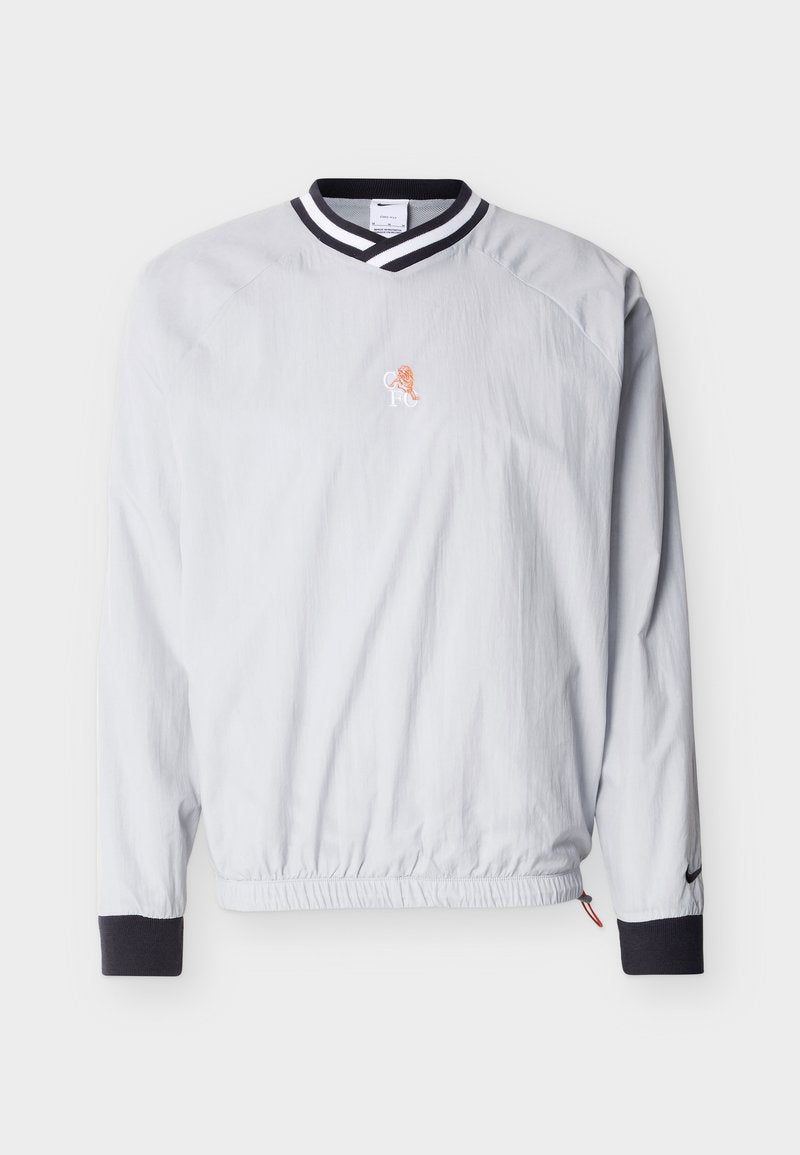 Hellgrauer Pullover mit schwarz-weiß gestreiftem V-Ausschnitt-Kragen, schwarzen Bündchen, elastischem Bund und kleinem orangefarbenem Löwenlogo auf der Brust.