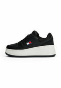 Schwarzer Sneaker mit einem glatten Lederobermaterial, weißer Plateau-Sohle und Logodetails in Rot, Weiß und Blau an der Seite.