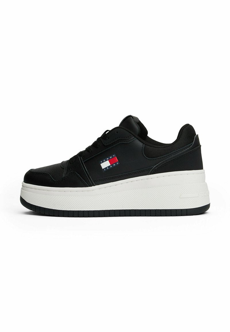Schwarzer Sneaker mit einem glatten Lederobermaterial, weißer Plateau-Sohle und Logodetails in Rot, Weiß und Blau an der Seite.