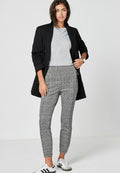 Schwarze Blazer, graues T-Shirt und grau-weiße karierte, tapered Hose mit glatter Textur; kombiniert mit weißen Sneakern mit schwarzen Streifen.