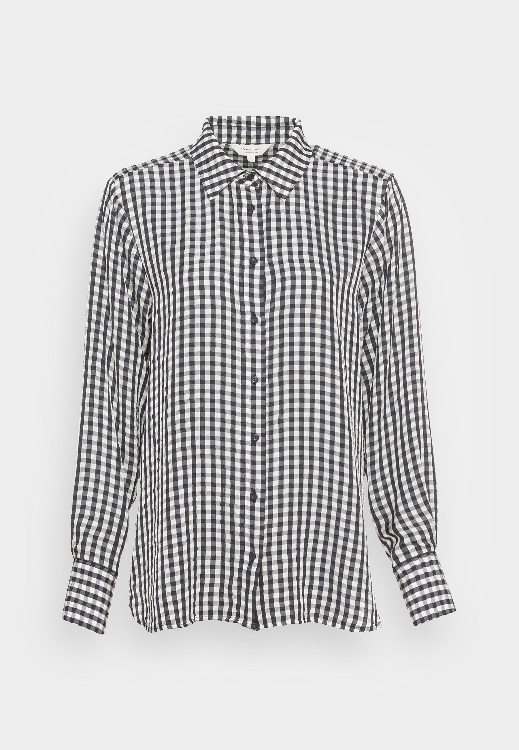 Schwarz-weiße Karobluse mit langen Ärmeln, klassischem Kragen und lässiger Passform; mit dunklen Knöpfen und strukturiertem Stoff.