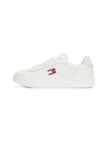 Weiße Ledersneaker mit glatter Oberfläche, flacher Gummisohle und einem kleinen Logo-Patch mit roten und blauen Streifen an der Seite.