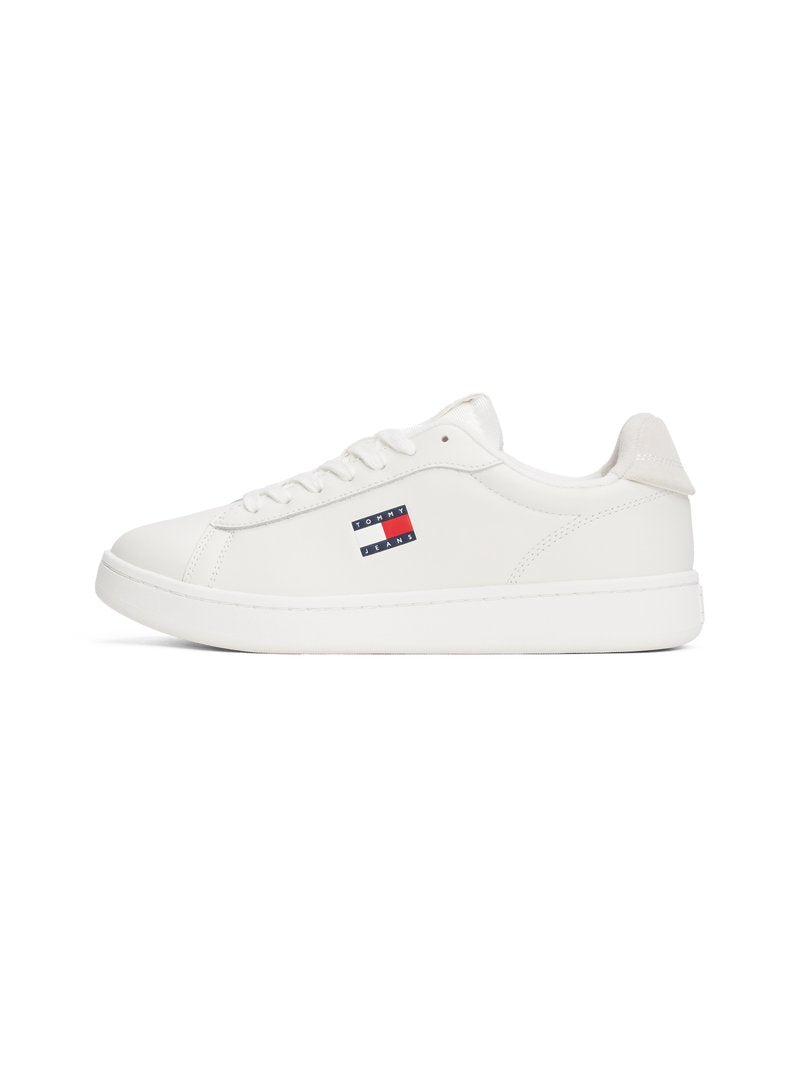 Weiße Ledersneaker mit glatter Oberfläche, flacher Gummisohle und einem kleinen Logo-Patch mit roten und blauen Streifen an der Seite.