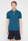 Türkisfarbenes Poloshirt mit gestreiftem Kragen, kurzen Ärmeln und geradem Schnitt. Wird mit dunklen Shorts getragen. Glatte Stoffstruktur, lässiges Design.