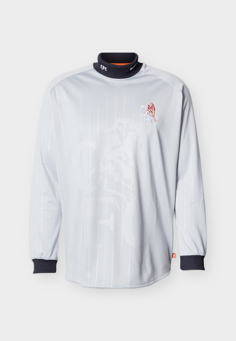 Langärmeliges weißes Sporttrikot mit schwarzem Kragen und Bündchen, mit einem roten Löwenemblem und den Initialen "CFC" auf der Brust.