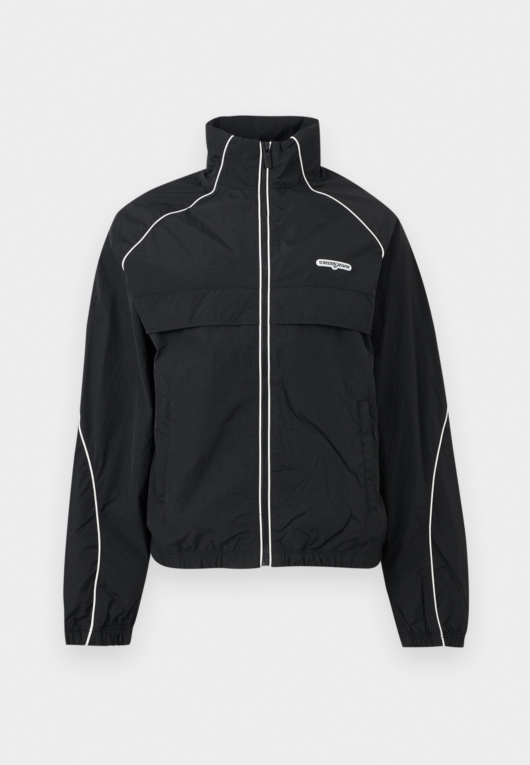 Schwarze Trainingsjacke mit Reißverschluss, weißen Kanten, hohem Kragen, elastischen Bündchen und "tommy jeans"-Logo auf der linken Brust.