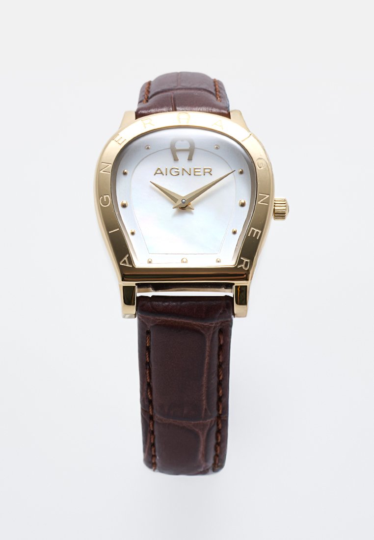 Goldene Aigner-Armbanduhr mit weißem Zifferblatt, minimalistischen goldenen Markierungen, braunem Lederarmband und goldfarbenem Gehäuse in Form eines umgekehrten Hufeisens.