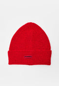 Rote gestrickte Beanie-Mütze mit umgeschlagenem Bündchen und schwarzem "PINKO"-Etikett mittig auf dem Bündchen, vor weißem Hintergrund.