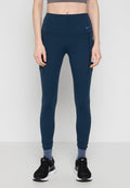 Person, der navyblaue, hoch taillierte Leggings mit seitlichen Taschen, graue Socken bis zum Knöchel und schwarze Nike-Laufschuhe trägt, steht vor einem weißen Hintergrund.
