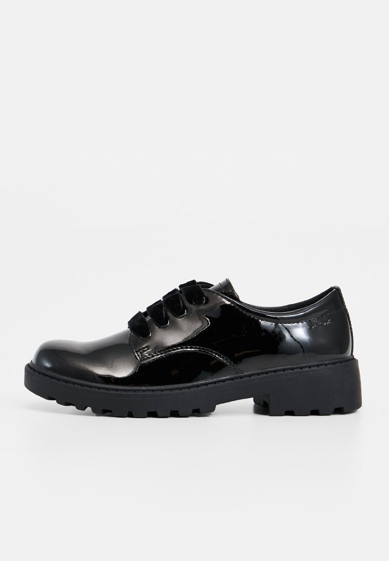 Schwarze Lacklederschuhe mit Schnürung, kontrastierender schwarzer, dicker Sohle und strukturierten Akzenten. Verfügt über sechs Ösen und ein glattes, geschwungenes Design.
