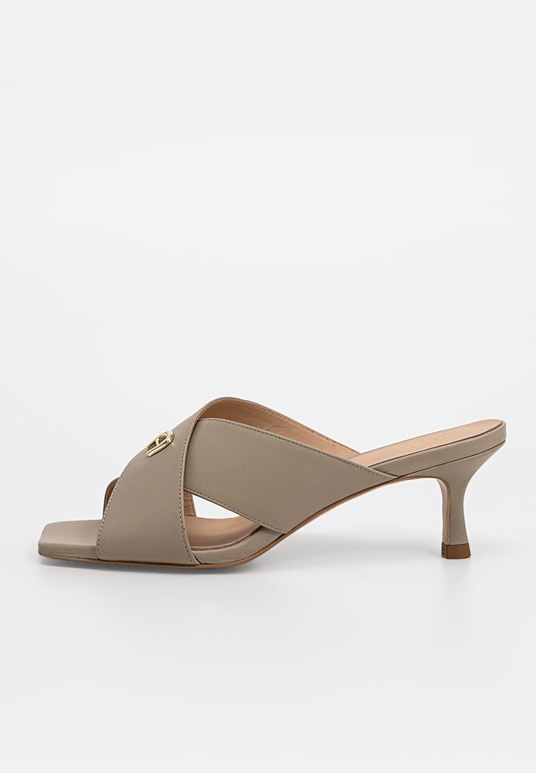Beige Absatzsandalen mit einem gekreuzten Riemendesign, glattem Leder, offenem Zehenbereich und einem kleinen Blockabsatz. Hervorstechendes goldenes Zubehör.