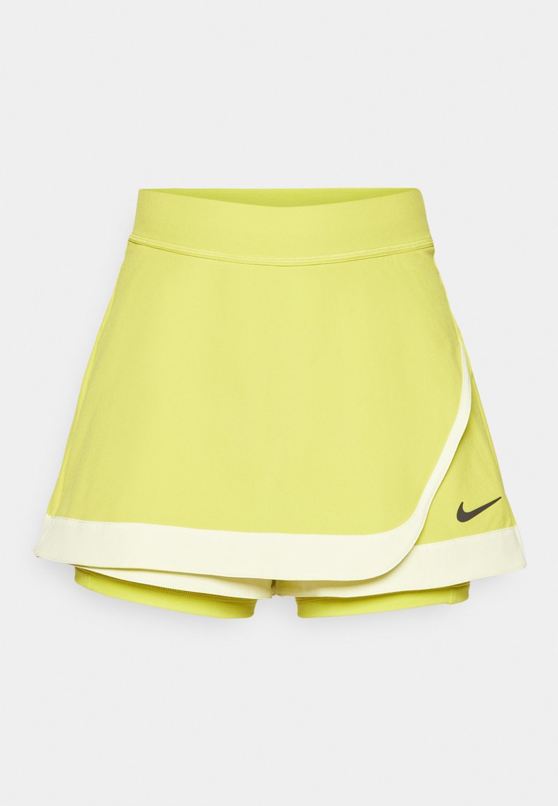 Limettengrüner Tennisrock mit angenähten Shorts; verfügt über ein geschichtetes Design, schwarzes Nike-Logo und weißen Saum.