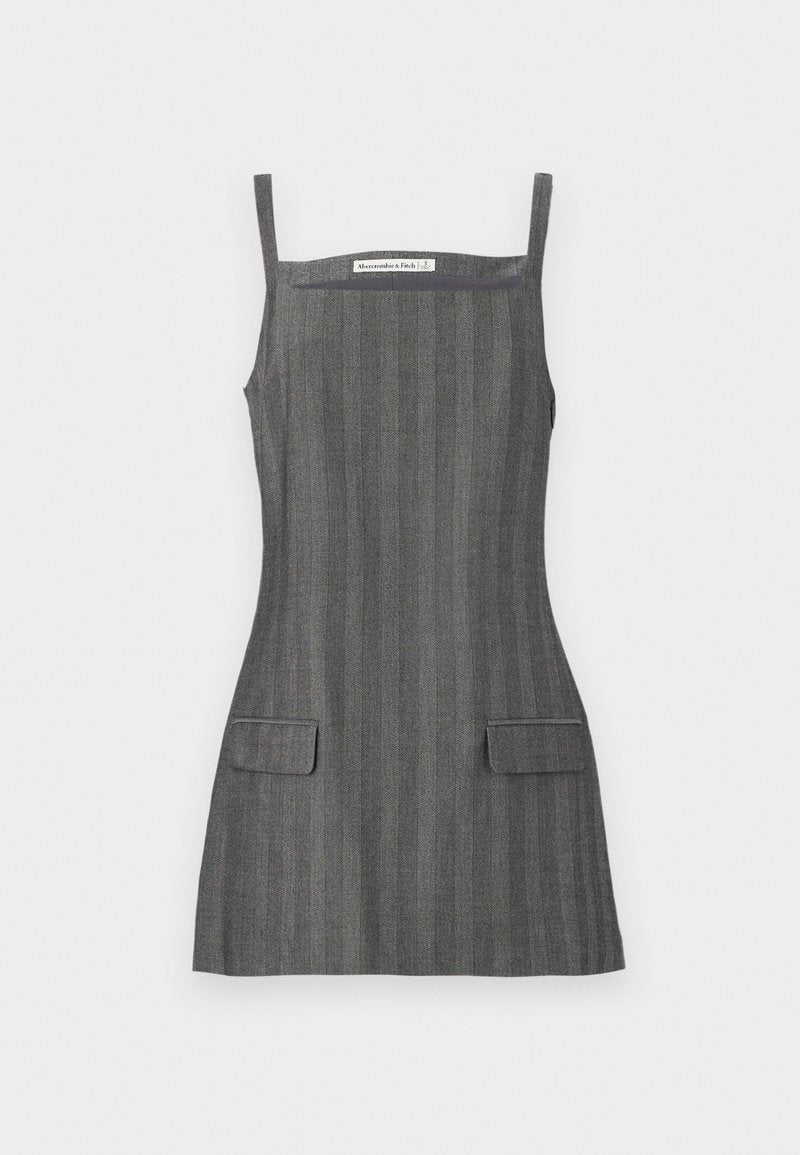 Grau gestreiftes Kleid mit dünnen Trägern, figurbetonter Silhouette und zwei aufgesetzten Taschen vorne. Das Material wirkt strukturiert mit dezenten vertikalen Streifen.