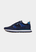 Marineblaue Sportschuh mit hellblauen Akzenten, weißem Innenfutter, mehrschichtiger Sohle in Weiß, Türkis und Blau sowie braunem profiliertem Sohlenboden.