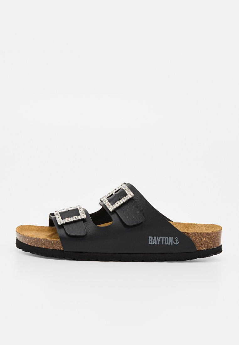 Schwarze Slip-On-Sandale mit Korksohle, zwei verstellbaren Riemen mit Strassschnallen und "BAYTON" Logo an der Seite.