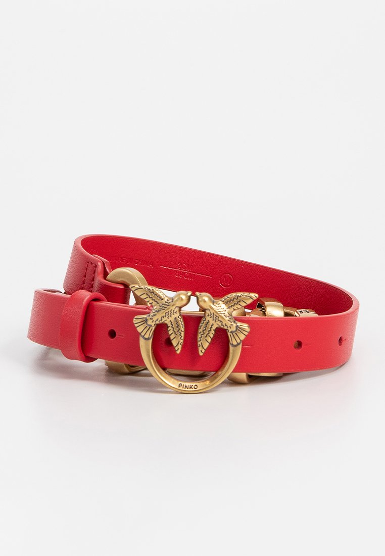 Roter Leder-Gürtel mit einer runden goldenen Schnalle, die mit zwei Vogelmotiven verziert ist. Verstellbare Passform mit mehreren Löchern zum Befestigen.