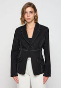Schwarzer Blazer mit kontrastierenden weißen Nähten, taillierter Schnitt, vorderen Taschen und Reverskragen, hergestellt aus texturiertem Stoff.