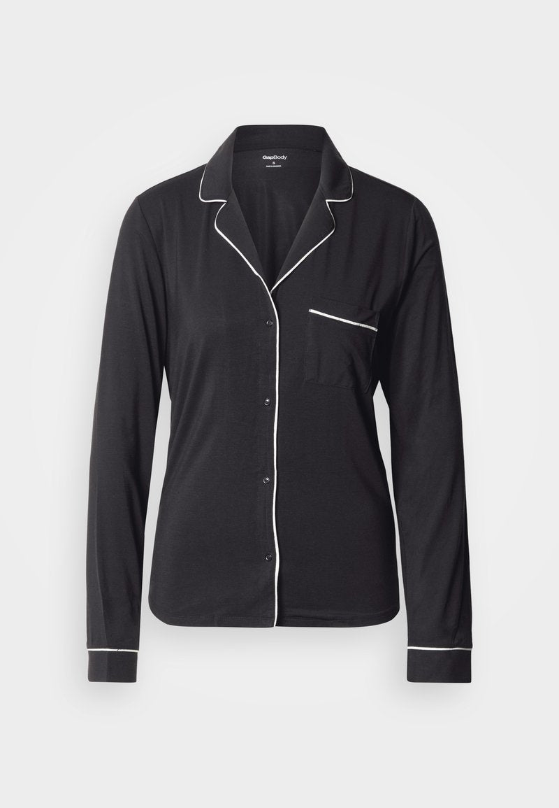 Schwarzes langärmliges Pyjamaoberteil aus weichem Stoff, mit weißen Paspeln entlang des Kragens, der Knopfleiste und der Tasche. Klassisches Knopfverschluss-Design.