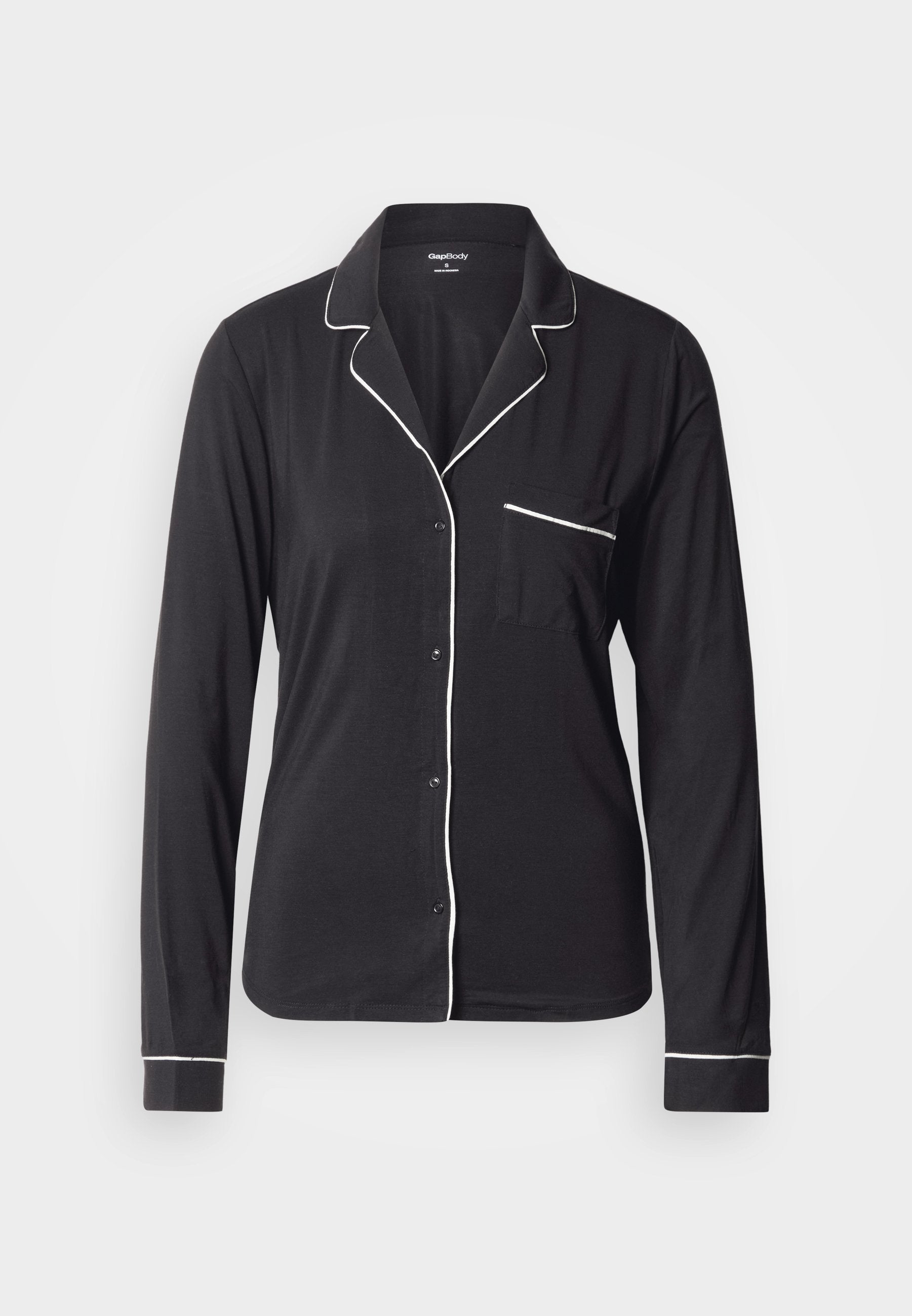 Schwarzes langärmliges Pyjamaoberteil aus weichem Stoff, mit weißen Paspeln entlang des Kragens, der Knopfleiste und der Tasche. Klassisches Knopfverschluss-Design.