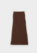 Braunes Leinenkleid mit dünnen cremefarbenen Trägern, geradem Schnitt und minimalen Details. Sanfte Textur, mittellang, geeignet für lässige Anlässe.