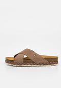 Brauner Veloursleder-Pantolette mit gekreuzten Riemen, gepolsterter Korksohle, geflochtenem Rand und kleinem rundem Metallemblem am Riemen.