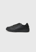 Schwarze Ledersneaker mit strukturiertem Finish, runder Zehenform, Schnürdesign und einer massiven schwarzen Gummisohle. Minimale Markenpräsentation an der Seite.