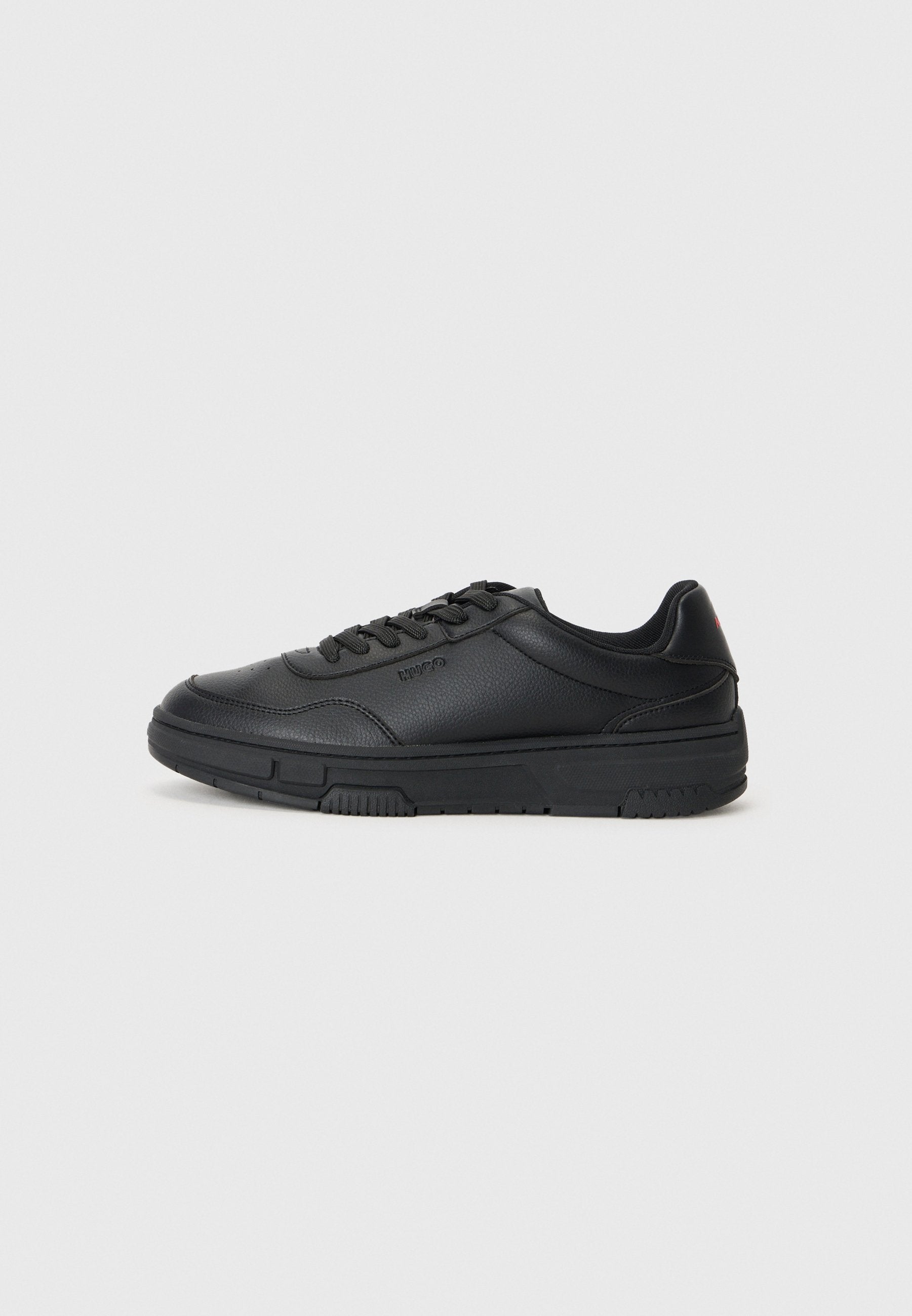 Schwarze Ledersneaker mit strukturiertem Finish, runder Zehenform, Schnürdesign und einer massiven schwarzen Gummisohle. Minimale Markenpräsentation an der Seite.