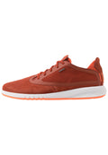 Rote Wildleder-Sneaker mit glatter Oberfläche, ausgestattet mit einer weißen Sohle mit orangefarbenen Akzenten und Schnürsenkeln, die für Komfort und Atmungsaktivität gestaltet sind.