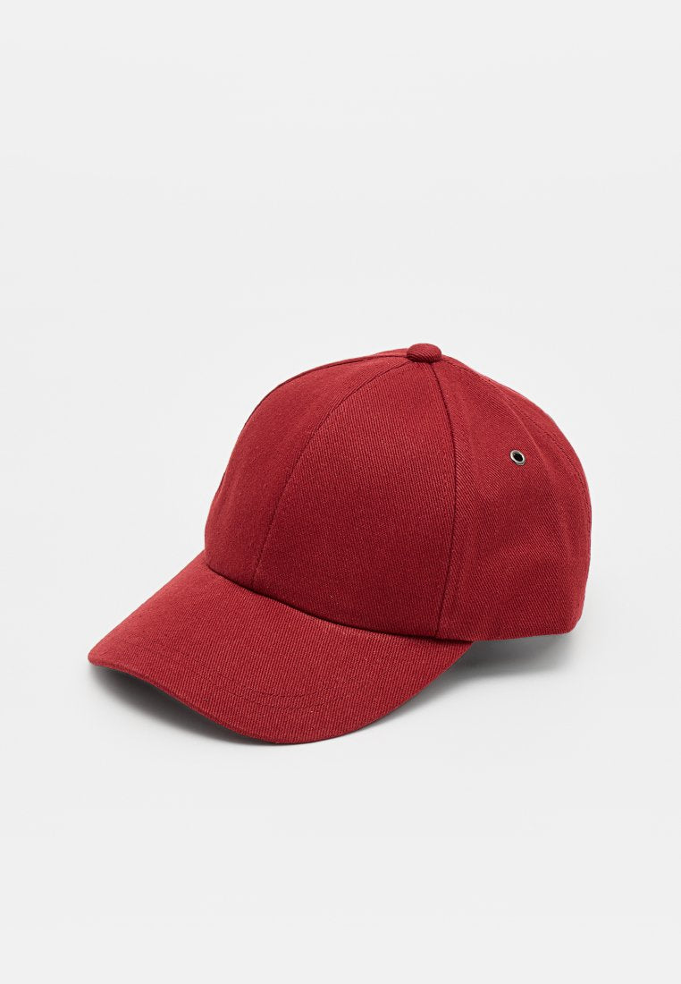 Rote Baseballkappe mit gebogenem Schirm und Knopf oben, mit einem Metall-Belüftungsösen an der Seite, abgebildet vor einem schlichten, hellen Hintergrund.