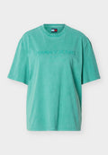 Grünes kurzärmeliges Baumwoll-T-Shirt mit "Tommy Jeans Since 1985 New York City" Stickerei auf der Vorderseite und Rundhalsausschnitt.