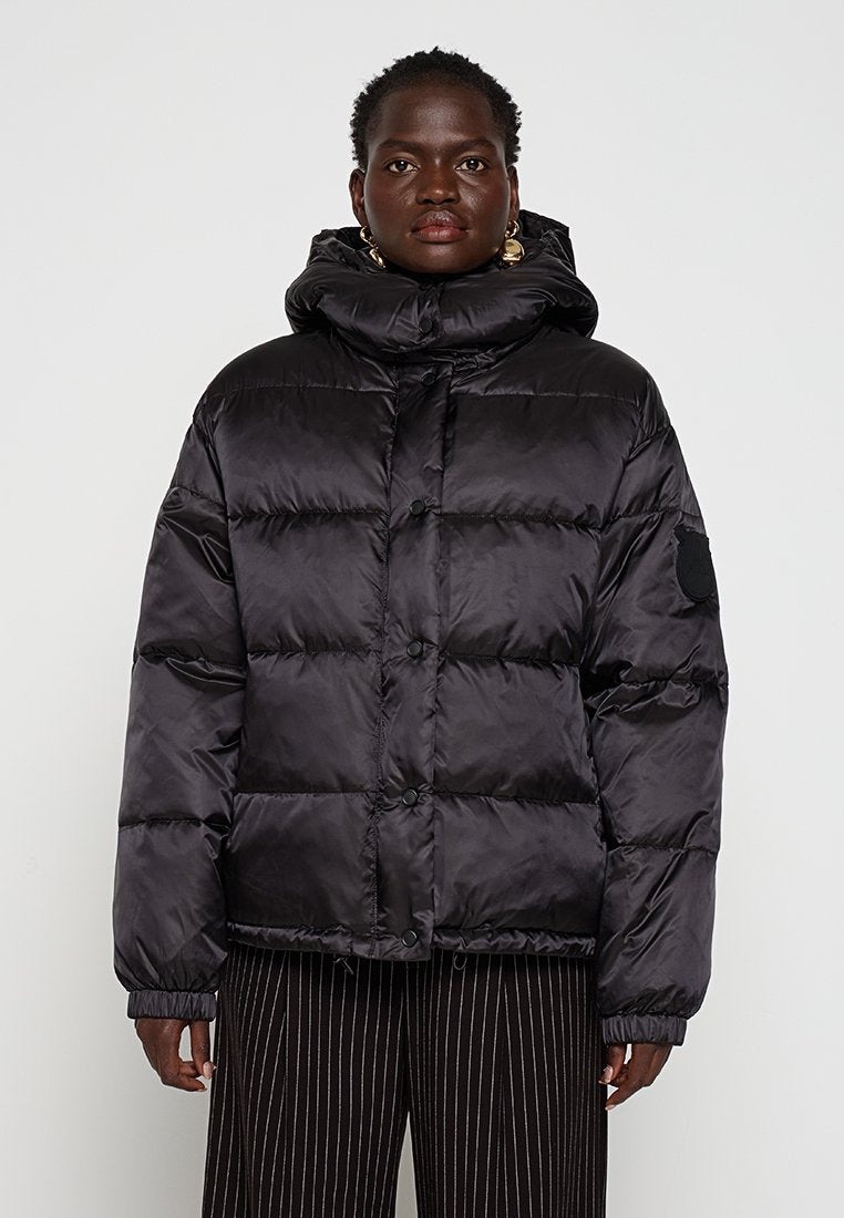 Schwarze Daunenjacke mit hochgeschlossenem Kragen, Knopfverschluss und elastischen Bündchen. Verfügt über genähte Steppabschnitte und ein Logo-Patch am Ärmel.