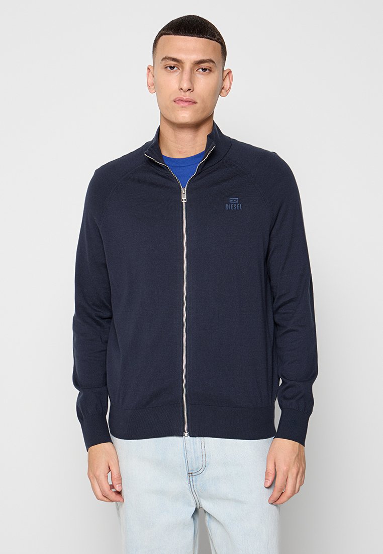Marineblauer Reißverschluss-Pullover aus weichem Stoff, mit hohem Kragen und dezentem Branding. Eng anliegend, mit gerippten Bündchen und Saum.