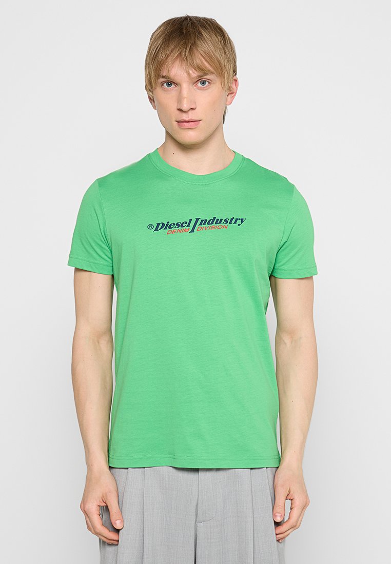 Grünes Rundhalsausschnitt-T-Shirt aus weichem Stoff mit bedrucktem Text in Marineblau und Rot, der "Diesel Industry DENIM DIVISION" sagt.