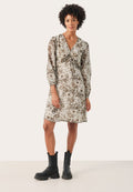 Blumendruckkleid in Beige und Braun mit langen Ärmeln, V-Ausschnitt und geknotetem Frontdetail. Kombiniert mit schwarzen Knöchelschuhen.