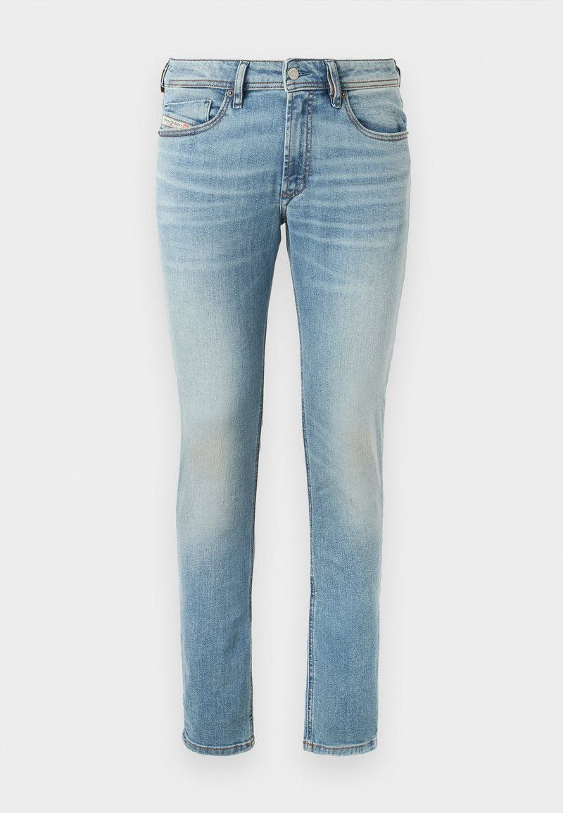 Hellblaue Denim-Jeans mit tailliertem Schnitt, fünf Taschen, subtilen Auswaschungen, mit Knopfverschluss und Gürtelschlaufen.