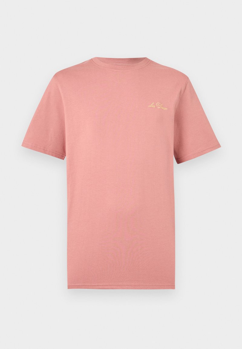 Schlichtes, gedämpftes rosa T-Shirt mit kurzen Ärmeln und kleinem gelbem, kursivem "Les Deux"-Logo auf der oberen linken Brust vor weißem Hintergrund.