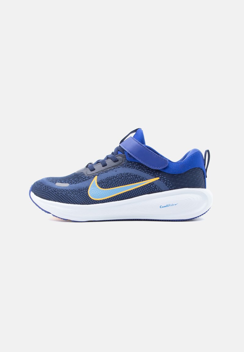 Blauer Sportschuh mit Mesh-Obermaterial, gelbem und hellblauem Nike-Swoosh, weißer ComfiRide-Sohle, Klettverschluss und Zuglasche an der Ferse.