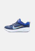 Blauer Sportschuh mit Mesh-Obermaterial, gelbem und hellblauem Nike-Swoosh, weißer ComfiRide-Sohle, Klettverschluss und Zuglasche an der Ferse.