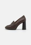 Braune Leder-High-Heel-Loafer mit abgerundeter Spitze, einem dekorativen Frontriemen und einem strukturierten Blockabsatz. Glatte Oberfläche mit subtiler Glanz.