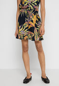 Blumenmusterkleid mit dunklem Hintergrund, geraffter Taille, ausgestelltem Saum und bunten Blattmustern. Begleitet von schwarzen flachen Schuhen.