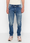 Helle blaue Denim-Jogginghose mit elastischem Bund und Kordelzug, ausgestattet mit Vordertaschen und einem verwaschenen Look. Kombiniert mit beigen Sneakers.