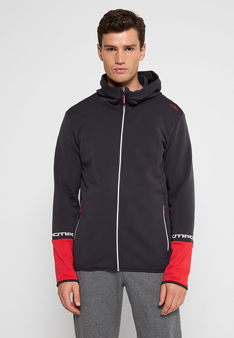 Schwarze Softshelljacke mit Reißverschluss vorne, roten Akzenten an den Ärmeln und Logo. Verfügt über eine Kapuze und zwei seitliche Taschen mit Reißverschlüssen.