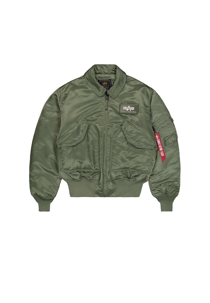 Olivgrüne Bomberjacke aus glattem, glänzendem Nylon. Verfügt über einen Reißverschluss, gerippte Bündchen und mehrere Taschen mit einem Etikett. 