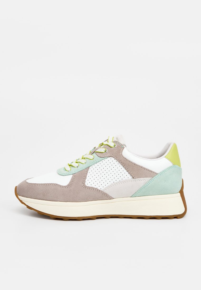 Legerer Sneaker mit beigen, weißen, mintgrünen und gelben Paneelen, perforierter Seite, grünen Schnürsenkeln und brauner Gummisohle auf weißem Hintergrund.