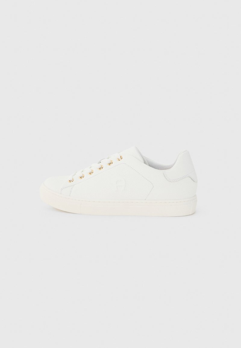 Weißer Sneaker mit niedrigem Schnitt, goldenen Ösen, weißen Schnürsenkeln und einem dezenten, geprägten Logo an der Seite, von der Außenseite gezeigt.