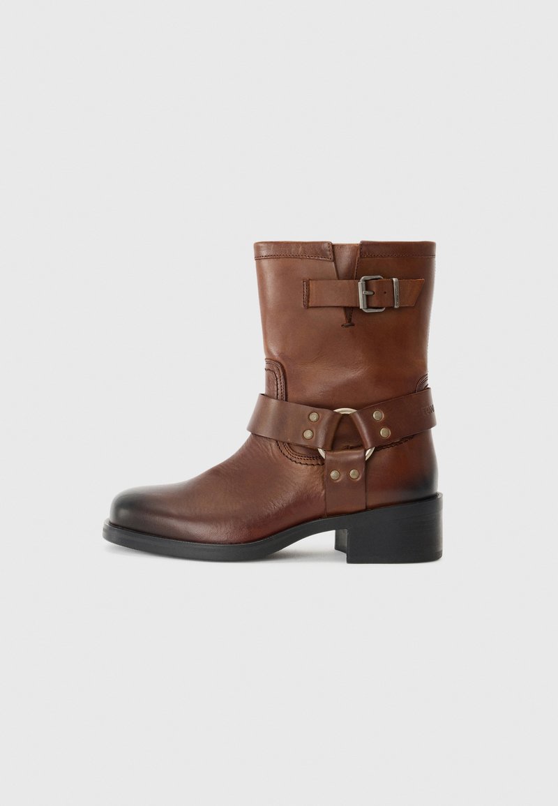 Braune Lederknöchelstiefel mit runder Zehenform, seitlichem Schnallendesign und niedrigem Blockabsatz. Glatte Oberfläche mit kontrastierenden metallischen Akzenten.