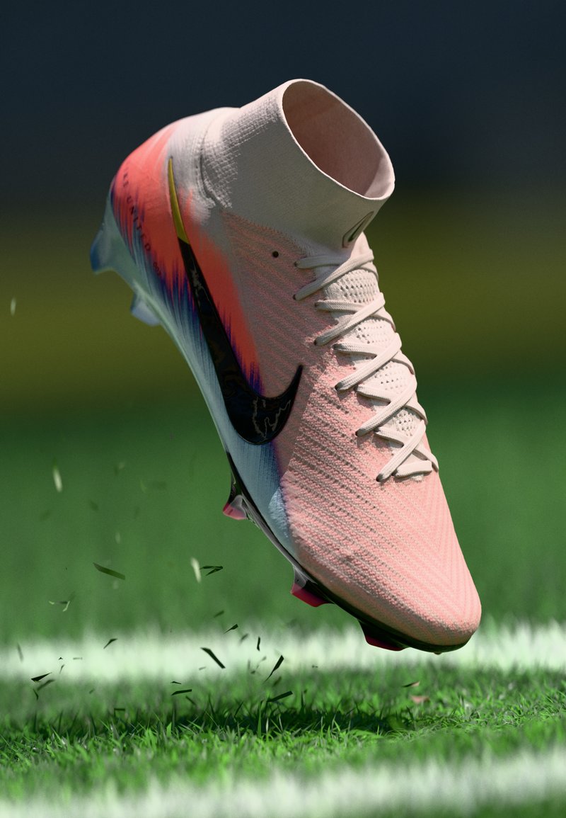 Rosa und weiße Nike Fußballschuhe mit schwarzem Swoosh, die Gras auf einem grünen Feld mit weißen Linien markieren.