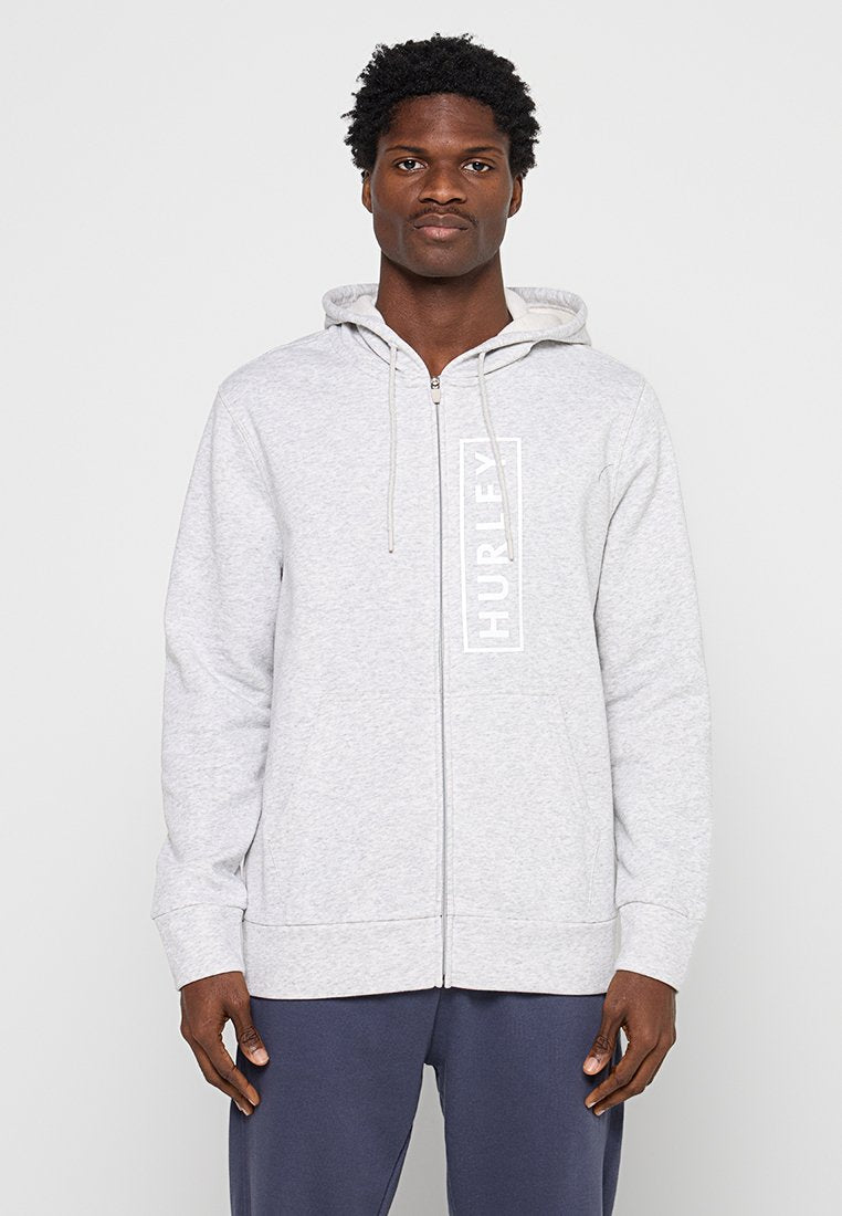 Grauer Kapuzenpullover mit Reißverschluss und Kapuze, mit einem weißen vertikalen "HURLEY"-Logo, gerippten Bündchen und einer Kängurutasche. Weiches Material aus Baumwollmischung.