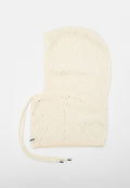 Cremefarbene Strick-Balaclava mit silbernen Strasssteinen und langen Bändern, entworfen, um Kopf und Hals vollständig zu bedecken.