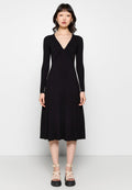 Schwarzes geripptes Kleid mit langen Ärmeln, V-Ausschnitt, tailliertem Oberteil und ausgestelltem A-Linien-Rock. Getragen mit beigen Plateausandalen.